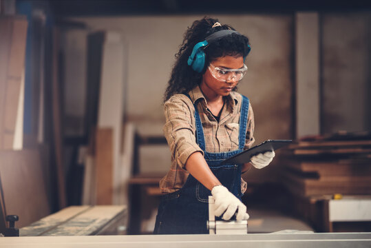 African american woman craftgirl working in handmade DIY workwood workshop, Small business owner in furniture industry.