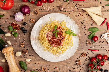 Spaghetti with Bolognese Sauce and Parmesan on Rustic Plate.
Traditional spaghetti with minced meat tomato sauce, topped with parmesan and basil, served on a rustic wooden background.