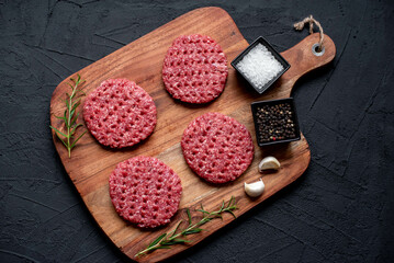 raw beef cutlets for burgers on stone background