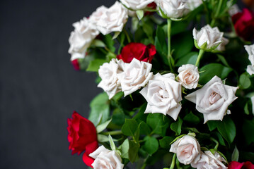 Obraz na płótnie Canvas bouquet of red and white roses on a stone background with copy space for your text