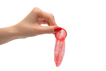 A red condom in a woman hand with red nails isolated on white background.