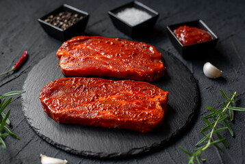 marinated raw pork steaks on stone background 