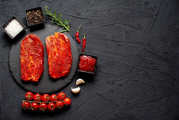 marinated raw pork steaks on stone background with copy space for your text