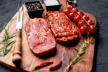 marinated raw pork steaks on stone background