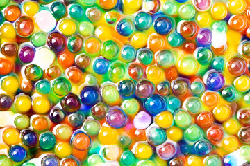 Fototapeta na wymiar Hydrogel balls texture. Absorbent gel pattern. Wet small beads. Shiny funny game for children background. Liquid cells besh. Vibrant colors circles background.