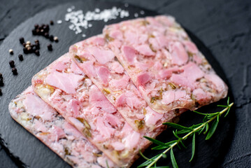 sliced ​​sausage with ham with cucumbers and onions on a stone background