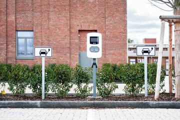 e-car charging station, also known as a e-car charge point or electric vehicle supply equipment (EVSE) Electric car charging station with information sign electric-car public charging station photo.