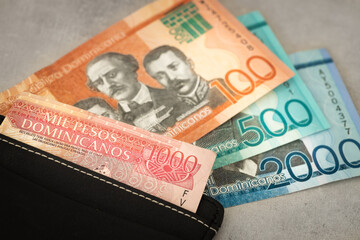 Obraz premium Dominican Republic currency, pesos banknotes, sticking out of wallet, close up, Travel business concept