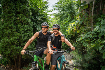 portrait of two men friends wear protective helmet during bike ride