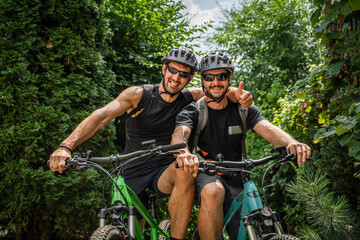 portrait of two men friends wear protective helmet during bike ride