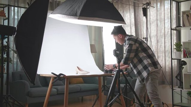 Asian Male Photographer Changing Camera'S Lens While Taking Photos Of Women'S Shoes In Home Studio 
