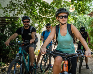 woman and man caucasian friends ride electric bicycle e-bike in summer