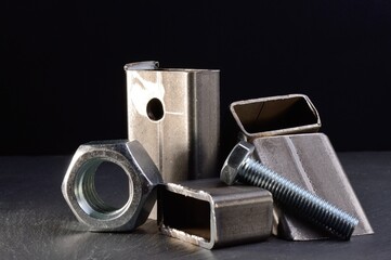 composition of nuts bolts and scraps of metal laid out on a dark background.