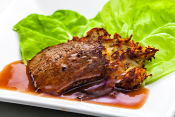 beef steak with sauce served with potato pankcakes