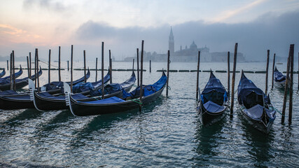 Fototapeta na wymiar Venice, Italy - 15 Nov, 2022: Morning views of gondolas, the Grand Canal, and San Giorgio Bell Tower