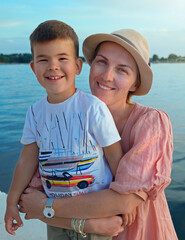 Portrait of smiling mother and baby boy hugging on the beach in Croatia - 580395044