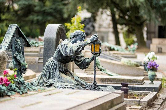 Impressive sculptures on the tombs and monuments of Cimitero Monumentale di Milano or Monumental Cemetery of Milan. Milan, Italy.