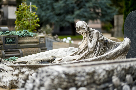 Impressive sculptures on the tombs and monuments of Cimitero Monumentale di Milano or Monumental Cemetery of Milan. Milan, Italy.