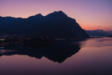 Fototapeta premium Stunning aerial cityscape of Lecco town on spring evening. Picturesque waterfront of Lecco town located between famous Lake Como and scenic Bergamo Alps mountains.