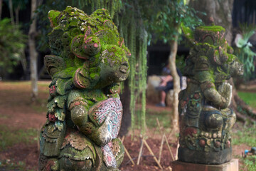 Moss covered woman headed God Statue a