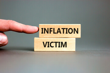 Inflation victim symbol. Concept words Inflation victim on wooden block. Beautiful grey table grey background. Businessman hand. Business inflation victim concept. Copy space.