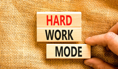 Hard work mode symbol. Concept words Hard work mode on wooden block on a beautiful canvas table...