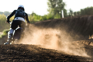 A young man, a man, an athlete, driving a motocross motorcycle in the blur, on a dirt track....