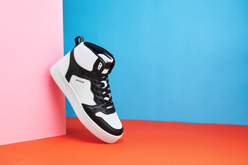 Black and white sneakers on a colored background. Stylish style footwear for advertising a shoe...