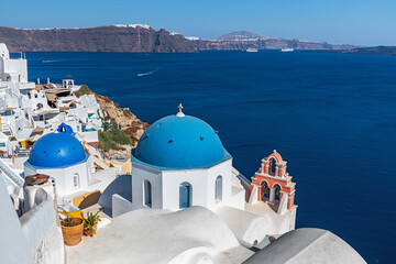 Fototapeta na wymiar Blue domes and orange bell tower on the island of Santorini. Greece.