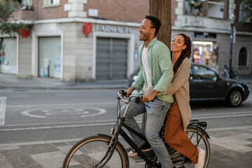 Fototapeta na wymiar happy tourist couple on electric bike, african american couple in the city