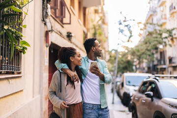 couple tourists in the city - african american travelers with smart phone