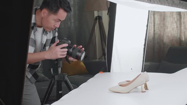 Asian Male Photographer Walking Into Home Studio And Taking Photos Of Women'S Shoes 
