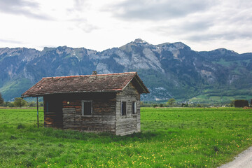 Fototapeta na wymiar Wooden alpine hut on meadow valley