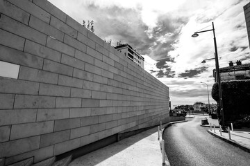 Black and white photo of big marble rock wall next to a curvy road