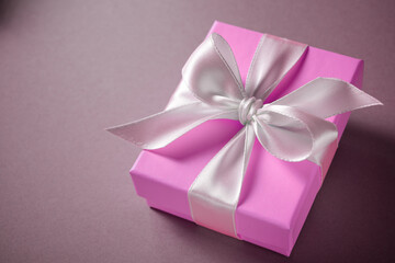 Pink gift box with a white ribbon - Powered by Adobe