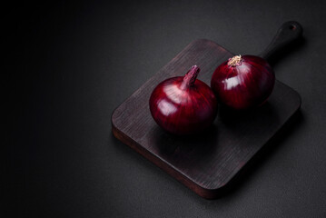 Fresh raw red onion on dark textured concrete background