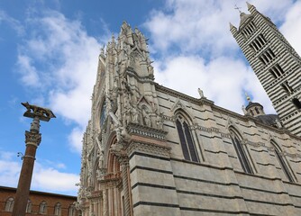 cathedral of SIENA in central Italy with the bell tower and the statue of the she-wolf with Romulus...