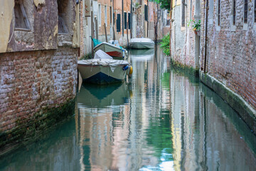 Old houses and boats on a quiet and calm canal, Venice, Italy
