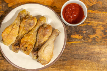 Roasted chicken legs and ketchup.