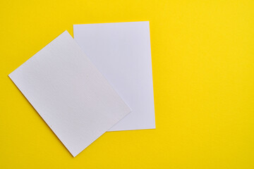 Blank white card isolated on yellow background. Place for text. Mock up greeting card. Form