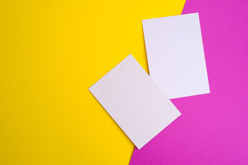 Blank white card isolated on pink and yellow background. Place for text. Mock up greeting card. Form