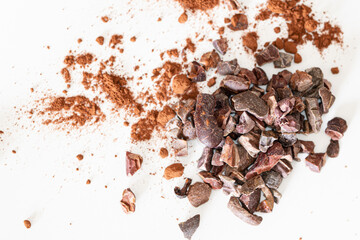 Dried and crushed cocoa beans closeup isolated on white background