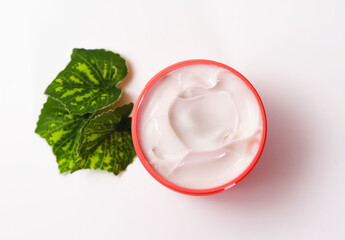Fototapeta na wymiar Delicate hand cream in a red container. Close-up of anti-aging cream