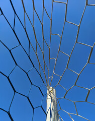 a grid of soccer goals against a blue sky