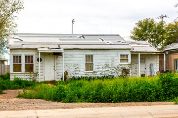 Abandoned Home In Disrepair With Overgrown Weeds