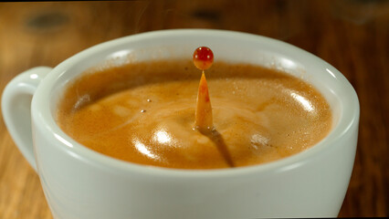Macro Shot of Coffee Drop Falling into Fresh Espresso Cup