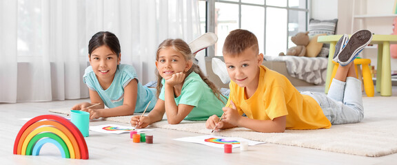 Little children painting rainbow at home