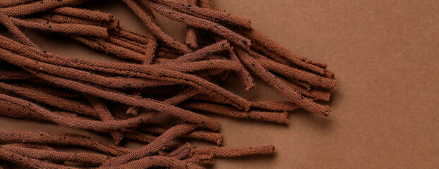 Fabric tassels on brown background