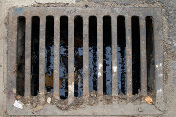 Dirty rectangular sewer or drain that installed in a street to collect rainwater - obrazy, fototapety, plakaty