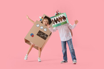 Little children in cardboard costumes on pink background